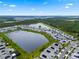 Aerial view of the community, featuring a serene lake surrounded by beautiful homes and lush greenery at 11381 Satire St, Orlando, FL 32832