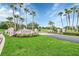 Community entrance with lush landscaping, stone accents, and palm tree lined street at 1195 Legendary, Clermont, FL 34711