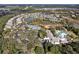 Beautiful aerial view of a residential community featuring a pool, lake, tennis courts, and clubhouse at 123 Avenham Drive, Deland, FL 32724