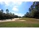 Expansive golf course view features meticulously maintained green and sand traps under a bright, partly cloudy sky at 123 Avenham Drive, Deland, FL 32724