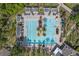 Aerial view of a large pool with palm trees, lounge chairs, umbrellas, and pergola covered seating at 123 Avenham Drive, Deland, FL 32724