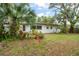 Lush backyard boasts tropical landscaping, mature trees, and a white home at 1307 Lindenwood Ln, Winter Park, FL 32792