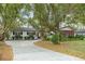 Charming home featuring mature trees, a brick accent wall, and a long driveway at 1307 Lindenwood Ln, Winter Park, FL 32792