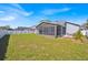 Expansive backyard featuring a lush green lawn, white fence, and screened-in patio, perfect for outdoor living at 1409 Golf Course Pkwy, Davenport, FL 33837