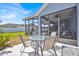 Outdoor table with view to screened lanai featuring ceiling fan, and backyard at 1409 Golf Course Pkwy, Davenport, FL 33837