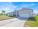 Wide view of the front of a single-story home with an attached garage and a well-manicured lawn at 1409 Golf Course Pkwy, Davenport, FL 33837