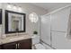 Bathroom with brown vanity and mirror, toilet with small plant, and shower with sliding glass door at 14923 Day Lily Ct, Orlando, FL 32824