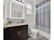 Modern bathroom showcasing a lighted mirror, dark vanity, and shower with stylish curtain at 2117 Trani Ter, St Cloud, FL 34771