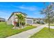 Well-maintained single-story home featuring a brick driveway, attached garage, and tropical landscaping at 2117 Trani Ter, St Cloud, FL 34771