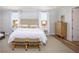 Bright bedroom with patterned headboard, bench, and bedside tables next to windows with white curtains at 2218 Elegant Maor Cir, Edgewater, FL 32141