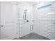 Modern shower with white subway tile, glass door, and gray stone-look shower floor at 2218 Elegant Maor Cir, Edgewater, FL 32141