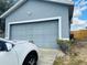 Image of a home with a two-car garage door and manicured landscaping along the driveway at 233 Ashley Loop, Davenport, FL 33837