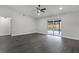 Spacious living room with dark floors, ceiling fan, and sliding glass doors leading to the pool area at 2335 Montano St, Deltona, FL 32738