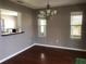 Bright dining area with hardwood floors, a modern chandelier, and an open view to the kitchen at 2628 Caribe Dr, The Villages, FL 32162