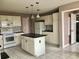 Functional kitchen with white cabinetry, black countertops, and a convenient center island at 2628 Caribe Dr, The Villages, FL 32162