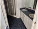 Bright bathroom featuring double sinks, updated countertops, tile floors, and a glass shower enclosure at 2628 Caribe Dr, The Villages, FL 32162