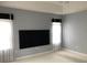 Bright bedroom featuring two windows with decorative curtains and a television feature wall at 2628 Caribe Dr, The Villages, FL 32162