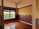 A cozy bedroom features hardwood floors, decorative wallpaper, and a bright window at 2628 Caribe Dr, The Villages, FL 32162
