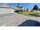 View of the exterior of a single Gathering home with paved driveway and manicured lawn and landscaping at 2628 Caribe Dr, The Villages, FL 32162