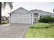 Charming single-story home featuring a two-car garage and a well-manicured front yard at 2628 Caribe Dr, The Villages, FL 32162