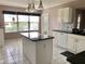 Bright kitchen features white cabinets, black countertops, and a spacious island perfect for meal prep at 2628 Caribe Dr, The Villages, FL 32162