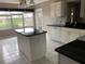 Bright kitchen features white cabinets, black countertops, and a spacious island perfect for meal prep at 2628 Caribe Dr, The Villages, FL 32162