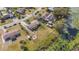 Aerial shot of a home with a spacious yard bordering a pond, featuring outbuildings and a firepit at 2662 Hibiscus Ct, Deltona, FL 32738