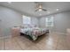 Bright bedroom with a ceiling fan, tiled floors, two windows, and light-colored walls at 2662 Hibiscus Ct, Deltona, FL 32738