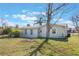 Back exterior view of the house with a large yard and mature trees at 2662 Hibiscus Ct, Deltona, FL 32738