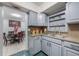 Cozy kitchen featuring gray cabinets, granite countertops, stainless steel sink, and adjacent dining area at 2662 Hibiscus Ct, Deltona, FL 32738