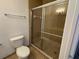 Bathroom featuring a shower with glass doors, toilet and tiled floor at 3177 Feltrim Pl # 304, Kissimmee, FL 34747