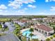 Aerial view of a community featuring a pool with sun loungers, palm trees and nearby buildings at 3204 Gold Ln, Kissimmee, FL 34747