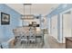 Dining room with a stylish table, chairs and a modern light fixture adjacent to kitchen with stainless steel appliances at 3204 Gold Ln, Kissimmee, FL 34747