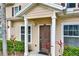 Inviting townhome entrance featuring manicured shrubbery, tropical landscaping and a cozy covered entryway at 3204 Gold Ln, Kissimmee, FL 34747