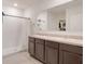 Well-lit bathroom with double sinks, dark cabinetry, and a walk-in shower for modern convenience at 3871 Brant Pl, Leesburg, FL 34748