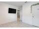 A room with marble flooring, a black television, and a door adorned with decorative vines at 3871 Brant Pl, Leesburg, FL 34748