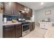 Gourmet kitchen featuring stainless steel appliances, dark cabinetry, and stylish backsplash at 3871 Brant Pl, Leesburg, FL 34748