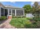 A tranquil backyard with a screened in porch, lush lawn and manicured garden beds at 4268 Ethan Ln, Orlando, FL 32814