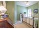 A charming bedroom features light green walls, white shutters, and cottage decor at 4268 Ethan Ln, Orlando, FL 32814