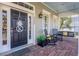 Inviting front porch featuring rocking chairs, swing, decorative door and brick flooring at 4268 Ethan Ln, Orlando, FL 32814