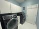 Well-equipped laundry room with modern black washer and dryer, white cabinets and blue walls at 4412 Conroy Club Dr, Orlando, FL 32835