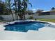 Inviting pool with an integrated spa surrounded by lush landscaping and a white fence at 4412 Conroy Club Dr, Orlando, FL 32835