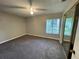 Bedroom featuring window, mirrored sliding closet doors, ceiling fan, and carpet flooring at 4439 Pinebark Ave # 47-4, Orlando, FL 32811