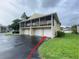 Exterior shot of condo showing balcony, 3 garages and front parking area at 4439 Pinebark Ave # 47-4, Orlando, FL 32811