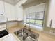 Close-up of a stainless steel kitchen sink under a window, complemented by light countertops and white cabinets at 4439 Pinebark Ave # 47-4, Orlando, FL 32811