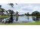 Scenic pond view featuring a fountain, lush green landscape, mature trees and tranquil water at 4439 Pinebark Ave # 47-4, Orlando, FL 32811