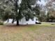 Charming home exterior featuring a spacious yard with mature trees and a black iron fence at 4900 Grand Ave, De Leon Springs, FL 32130