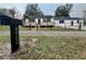 Inviting front exterior with a new wood deck, fence, and modern mailbox with street address at 4900 Grand Ave, De Leon Springs, FL 32130