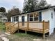 Newly built front porch with natural wood, stairs, and white railings that adds curb appeal at 4900 Grand Ave, De Leon Springs, FL 32130