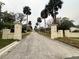 View of the wide street lined with large palm trees, leading to a neighborhood entrance at 4900 Grand Ave, De Leon Springs, FL 32130